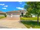 Inviting front exterior featuring a two-car garage, brick driveway, and tidy landscaping at 3632 Gretchen Dr, Ocoee, FL 34761