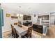 Modern kitchen with brown cabinetry, granite countertops, stainless steel appliances, and an island with a sink at 3632 Gretchen Dr, Ocoee, FL 34761