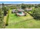 Aerial view of a home with a lush green lawn, pool, and beautiful landscaping at 3640 Crump Rd, Winter Haven, FL 33881