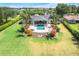 Aerial view of a home's backyard oasis with a sparkling pool, lush greenery, and patio furniture at 3640 Crump Rd, Winter Haven, FL 33881