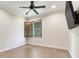 Neutral bedroom with a ceiling fan, wood-look flooring and a window with wood trim at 3640 Crump Rd, Winter Haven, FL 33881