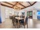 Open-concept dining area featuring a chandelier, wood ceiling beams, and a view into the kitchen at 3640 Crump Rd, Winter Haven, FL 33881