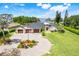 Stunning waterfront home featuring a three-car garage, circular driveway, lush landscaping, and picturesque water views at 3640 Crump Rd, Winter Haven, FL 33881