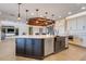 Large kitchen island with stainless dishwasher, farmhouse sink, white countertop, dark wood cabinets and modern lighting at 3640 Crump Rd, Winter Haven, FL 33881