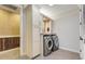 A modern laundry room features a front-load washer/dryer and custom cabinetry at 3640 Crump Rd, Winter Haven, FL 33881