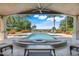 Covered outdoor patio seating with a view of a custom pool with bar seating and lake views at 3640 Crump Rd, Winter Haven, FL 33881