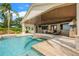 A covered patio with a stunning pool, bar seating, and outdoor kitchen offers the ultimate entertaining space at 3640 Crump Rd, Winter Haven, FL 33881