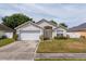 Charming single-story home featuring an attached two-car garage, well-maintained lawn, and neutral-toned facade at 3830 Spring Breeze Dr, Orlando, FL 32829