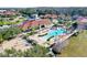 An aerial view shows the community pool with lounge chairs, picnic tables, and a sandy volleyball court at 4569 Cabello Loop, Kissimmee, FL 34746