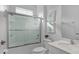 Bright bathroom with a tub and shower combo featuring glass doors and a white sink at 4569 Cabello Loop, Kissimmee, FL 34746