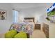Bright bedroom with a floral-patterned bedspread, wooden nightstands, and colorful artwork at 4569 Cabello Loop, Kissimmee, FL 34746