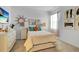 Well-lit bedroom with a white bed, colorful pillows, and decorative art pieces on the walls at 4569 Cabello Loop, Kissimmee, FL 34746
