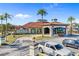 Community clubhouse featuring a clock tower, porte-cochere, and lush landscaping at 4569 Cabello Loop, Kissimmee, FL 34746