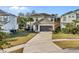 Charming two-story home features a well-maintained lawn, palm trees, and a two-car garage with a neutral-colored front door at 4569 Cabello Loop, Kissimmee, FL 34746