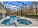 Private screened-in pool and spa with beautiful tile work, surrounded by lush landscaping at 4569 Cabello Loop, Kissimmee, FL 34746