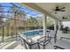 Screened-in pool area featuring outdoor seating, ceiling fans, and a view of the surrounding landscape at 4569 Cabello Loop, Kissimmee, FL 34746