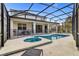 A screened-in pool and spa are surrounded by lounge chairs and an outdoor dining set on the patio at 4569 Cabello Loop, Kissimmee, FL 34746