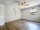 Bedroom with wood-look flooring, ceiling fan, built-in shelf, and a window A/C unit at 4887 Seminole Ave, Winter Park, FL 32792