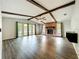 Bright living room featuring a brick fireplace, beamed ceilings, and hardwood floors at 4887 Seminole Ave, Winter Park, FL 32792