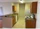 Functional kitchen featuring tile floors, wood cabinets, and updated appliances at 5550 E Michigan St # 2114, Orlando, FL 32822