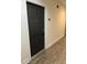 Hallway view of unit entry door, featuring wood-look laminate floors and neutral wall colors at 5550 E Michigan St # 2202, Orlando, FL 32822