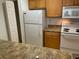 Efficient kitchen includes white appliances, laminate countertops, and wood cabinets at 5550 E Michigan St # 2202, Orlando, FL 32822