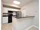 Open concept kitchen featuring a breakfast bar, stainless steel appliances, and ample storage space at 5578 Metrowest Blvd # 10, Orlando, FL 32811