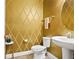 Powder room featuring gold diamond patterned wallpaper, pedestal sink, toilet, and decorative mirror at 645 American Holly Pl, Oviedo, FL 32765