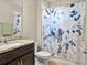 Bright bathroom featuring a granite vanity top and a floral patterned shower curtain at 645 American Holly Pl, Oviedo, FL 32765