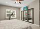 Bedroom with neutral walls, a bed with a patterned cover, windows with curtains, and a treadmill to promote a healthy lifestyle at 645 American Holly Pl, Oviedo, FL 32765
