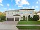Elegant two-story home with a manicured lawn, a three-car garage, and a stone-accented facade at 645 American Holly Pl, Oviedo, FL 32765