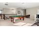 Spacious game room featuring a pool table, bar seating, and elegant chandelier lighting at 645 American Holly Pl, Oviedo, FL 32765
