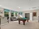 Upstairs game room with a pool table, bar area and a comfortable dark leather sofa at 645 American Holly Pl, Oviedo, FL 32765
