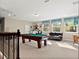 Spacious game room with a pool table, comfortable seating, and natural light from large windows at 645 American Holly Pl, Oviedo, FL 32765