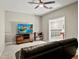 Carpeted living room with a ceiling fan, television, and a leather couch at 645 American Holly Pl, Oviedo, FL 32765