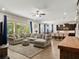 Open-concept living room with large sofa, access to the pool area, and view of the kitchen at 645 American Holly Pl, Oviedo, FL 32765