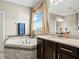 Elegant bathroom features a large soaking tub, a window, and stylish vanity at 645 American Holly Pl, Oviedo, FL 32765