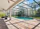 Inviting screened pool area with brick patio and outdoor kitchen, perfect for entertaining at 645 American Holly Pl, Oviedo, FL 32765
