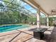 Relaxing screened pool with brick patio, fire table, and lush greenery, ideal for outdoor enjoyment at 645 American Holly Pl, Oviedo, FL 32765