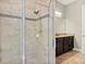 Modern shower with light beige tile and dark mosaic accent border and dark wooden vanity at 645 American Holly Pl, Oviedo, FL 32765