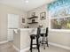 The wet bar features granite counters, bar stool seating, and a window with a treed view at 645 American Holly Pl, Oviedo, FL 32765