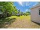 The home has a large grassy backyard, partially shaded by mature trees with a partial view of the neighboring homes at 73 Channing Ave, Orlando, FL 32811