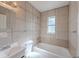 Tiled bathroom featuring a shower and tub combination and tiled walls at 73 Channing Ave, Orlando, FL 32811