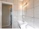 Standard bathroom featuring a white vanity, tile surround, and a small mirror with lighting at 73 Channing Ave, Orlando, FL 32811
