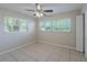 Bedroom featuring neutral walls, a ceiling fan, tiled floor, and multiple windows with blinds at 73 Channing Ave, Orlando, FL 32811