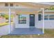 Covered front porch with a dark front door and black shutters on a single-story home at 73 Channing Ave, Orlando, FL 32811