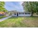 Single-story home with a well-manicured lawn, covered parking, and black window shutters at 73 Channing Ave, Orlando, FL 32811