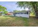Single-story home with a well-manicured lawn, covered parking, and black window shutters at 73 Channing Ave, Orlando, FL 32811