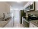 Modern galley kitchen with white cabinets, granite countertops, and stainless steel appliances at 73 Channing Ave, Orlando, FL 32811