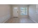 Open-concept living room with tile flooring, natural light, and a white front door at 73 Channing Ave, Orlando, FL 32811